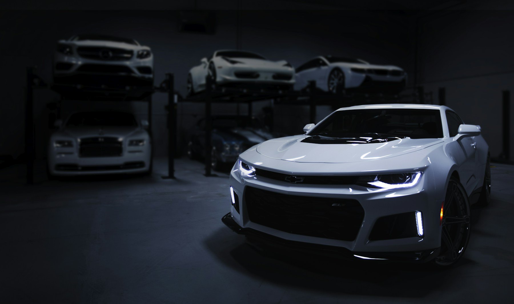 White performance coupe inside a dark car showroom